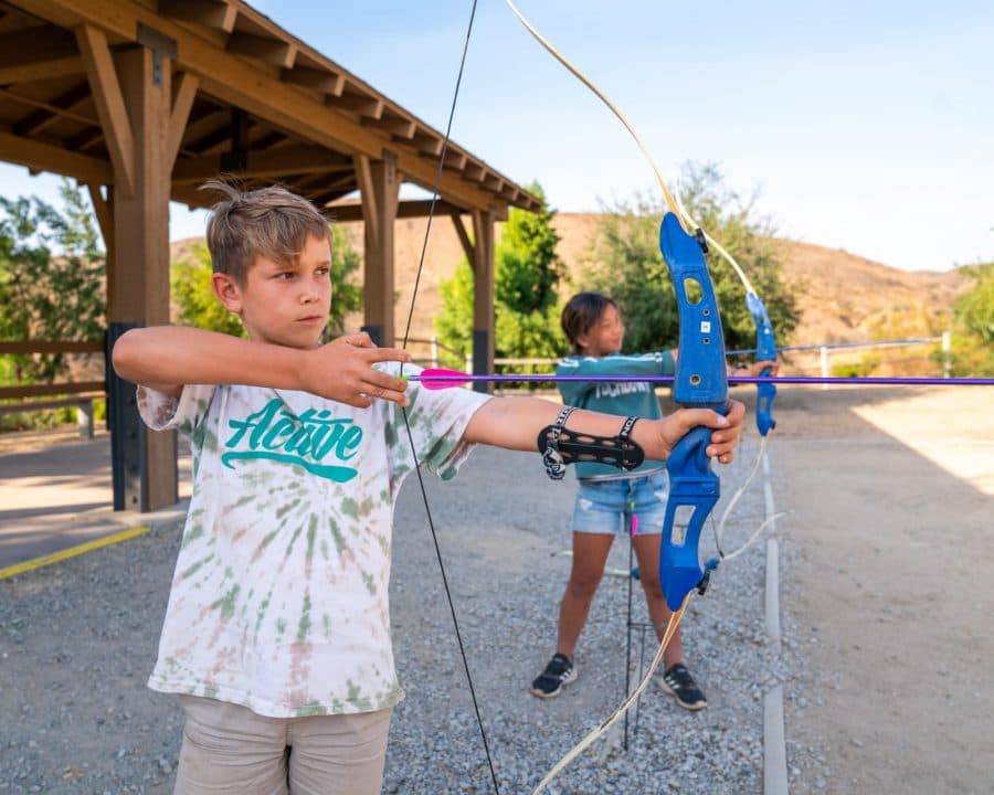 Kids learning archery outside